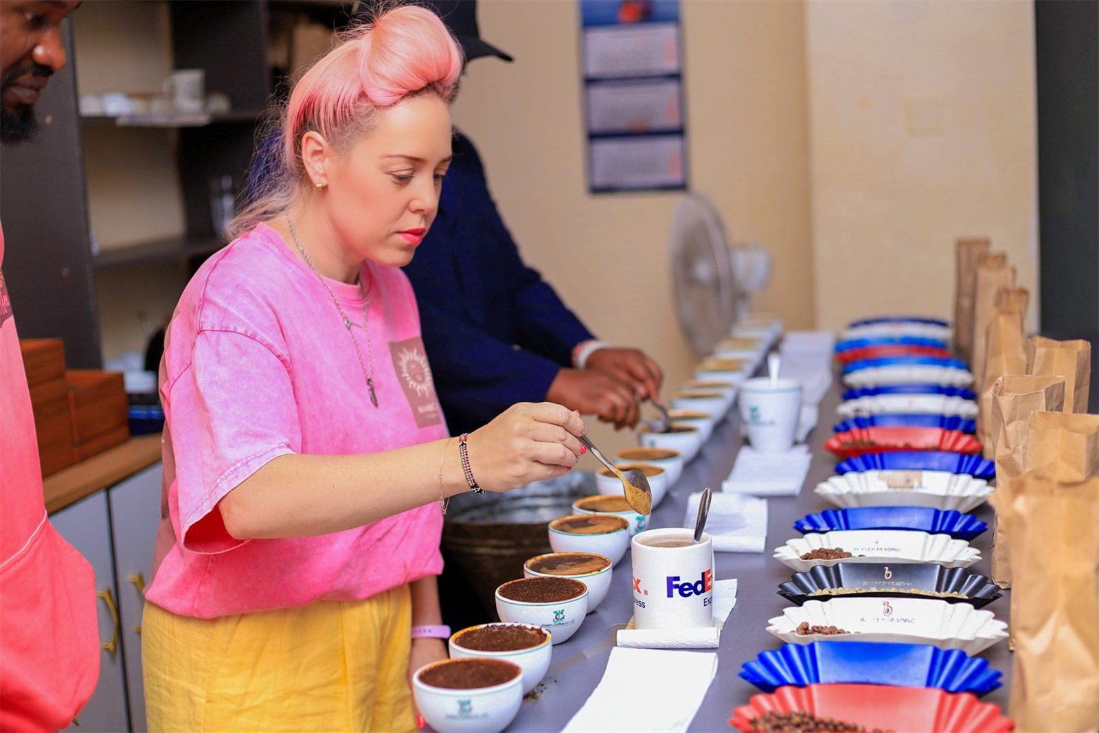 A founder cupping coffee samples at a row of bowls