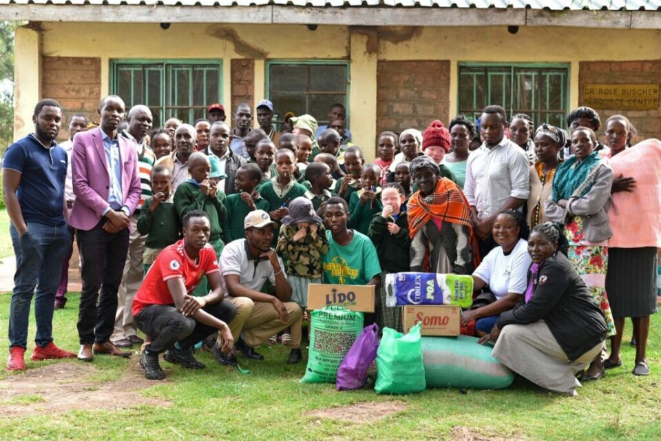 The Mambo Leo team with students and teachers at a community visit